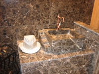 Agencement de salle de bains en marbre marron Emperador. Fabrication de vasque massive sur mesure. Vente de robinetterie en laiton.
